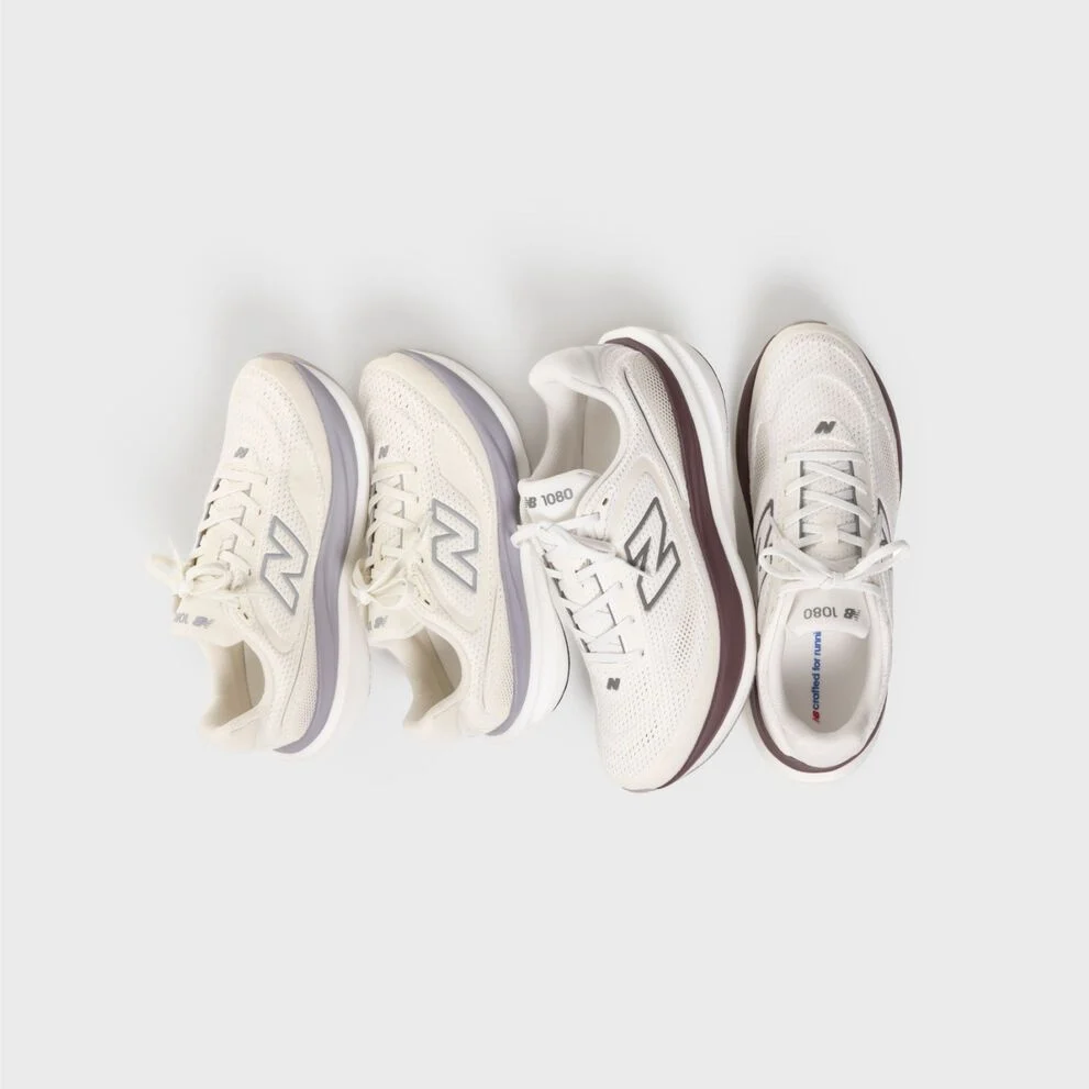 Two pairs of 1080 shoes on a grey background.
